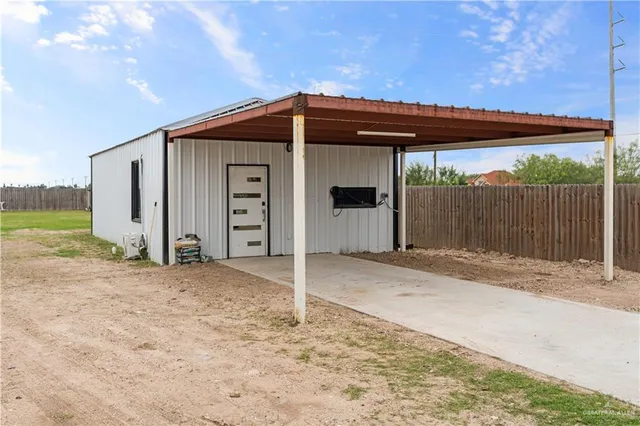 a view of a house with backyard and wooden fence