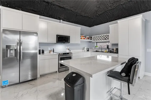 a kitchen with stainless steel appliances a microwave a sink a stove and refrigerator