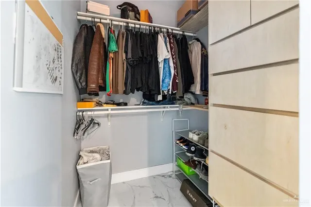 a view of walk in closet with clothes and shoes
