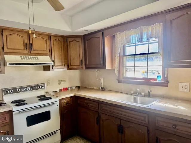 a kitchen with a sink cabinets appliances and a window