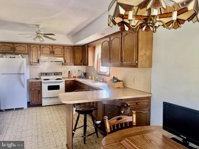 a kitchen with stainless steel appliances granite countertop a sink a stove and a refrigerator