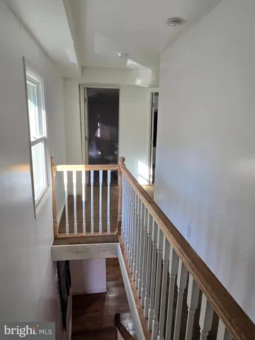 a view of staircase with railing and a window