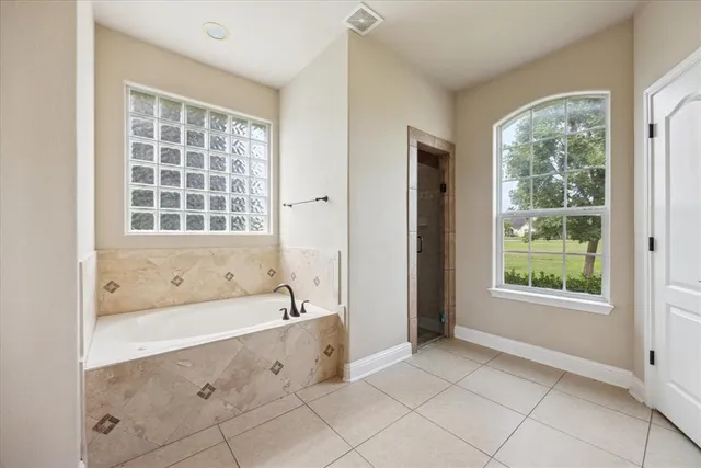 a bathroom with a granite countertop sink a mirror and a bathtub
