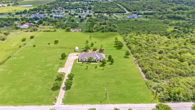 a yard with grassy field in back