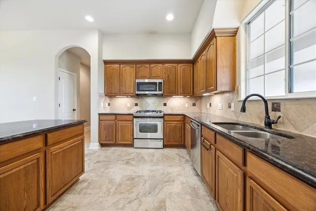a kitchen with stainless steel appliances granite countertop a sink and cabinets
