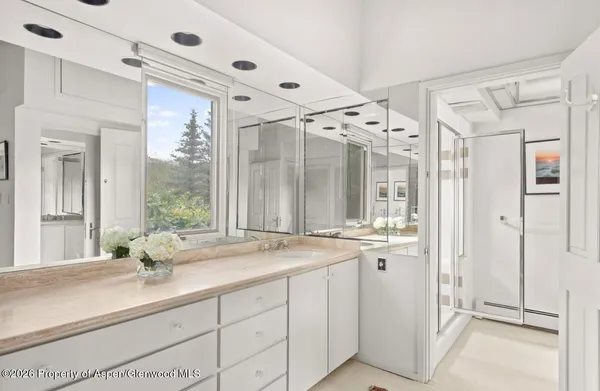 a large white kitchen with a sink and windows
