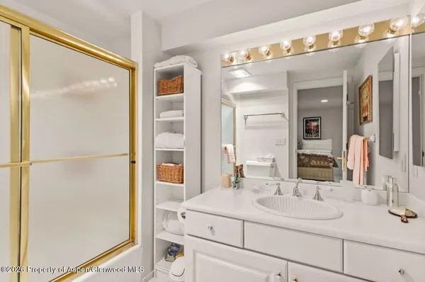 a bathroom with a sink a large mirror and a window