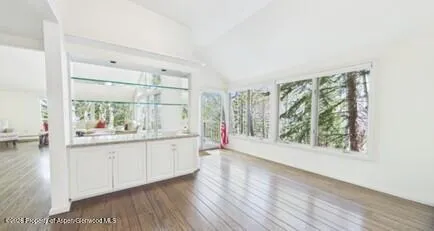 a view of a bedroom with wooden floor and windows
