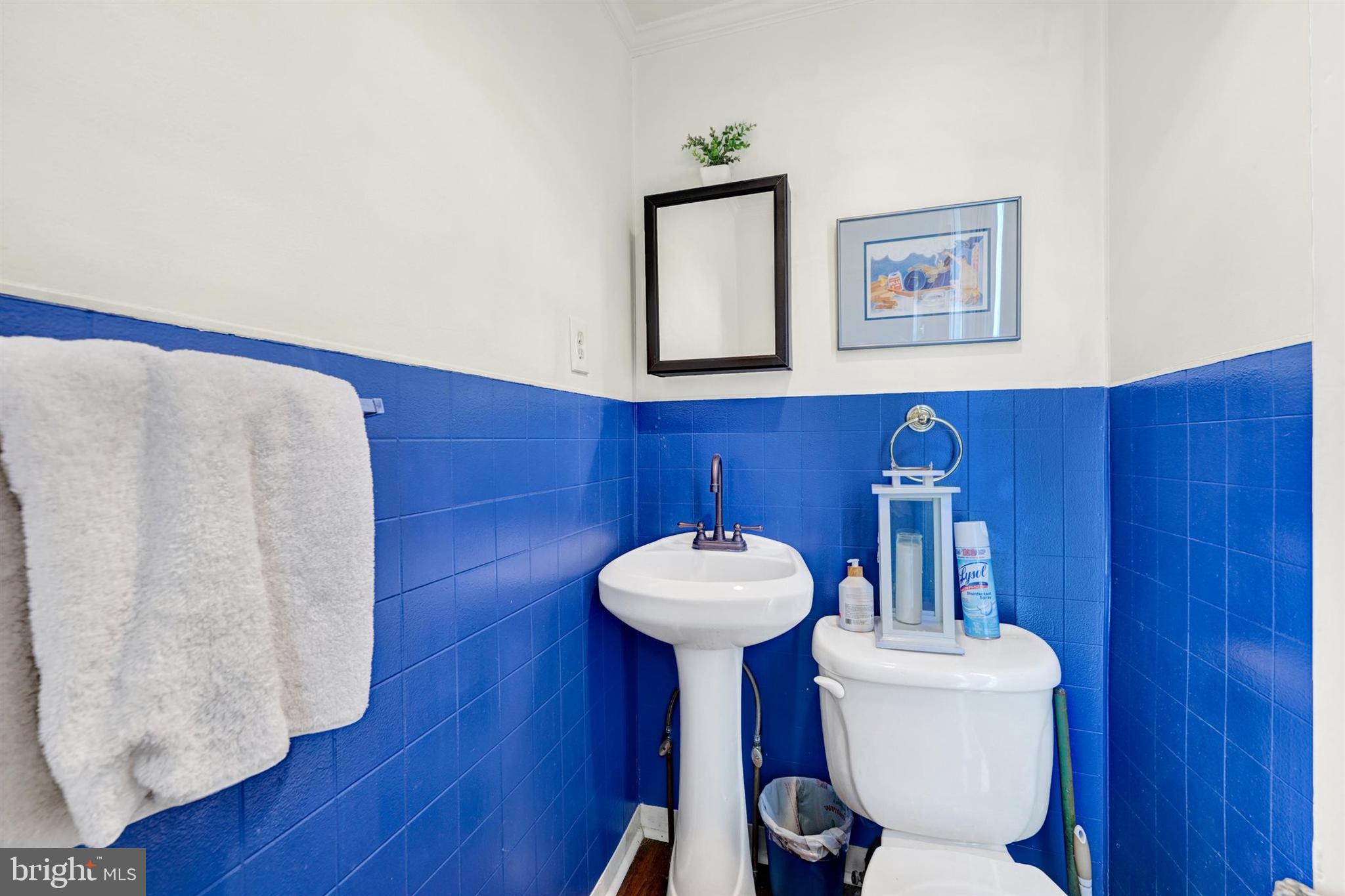 6406 Old Harford Road Baltimore, MD 21214 - Photo 15 of 26 a bathroom with a toilet a sink and a mirror
