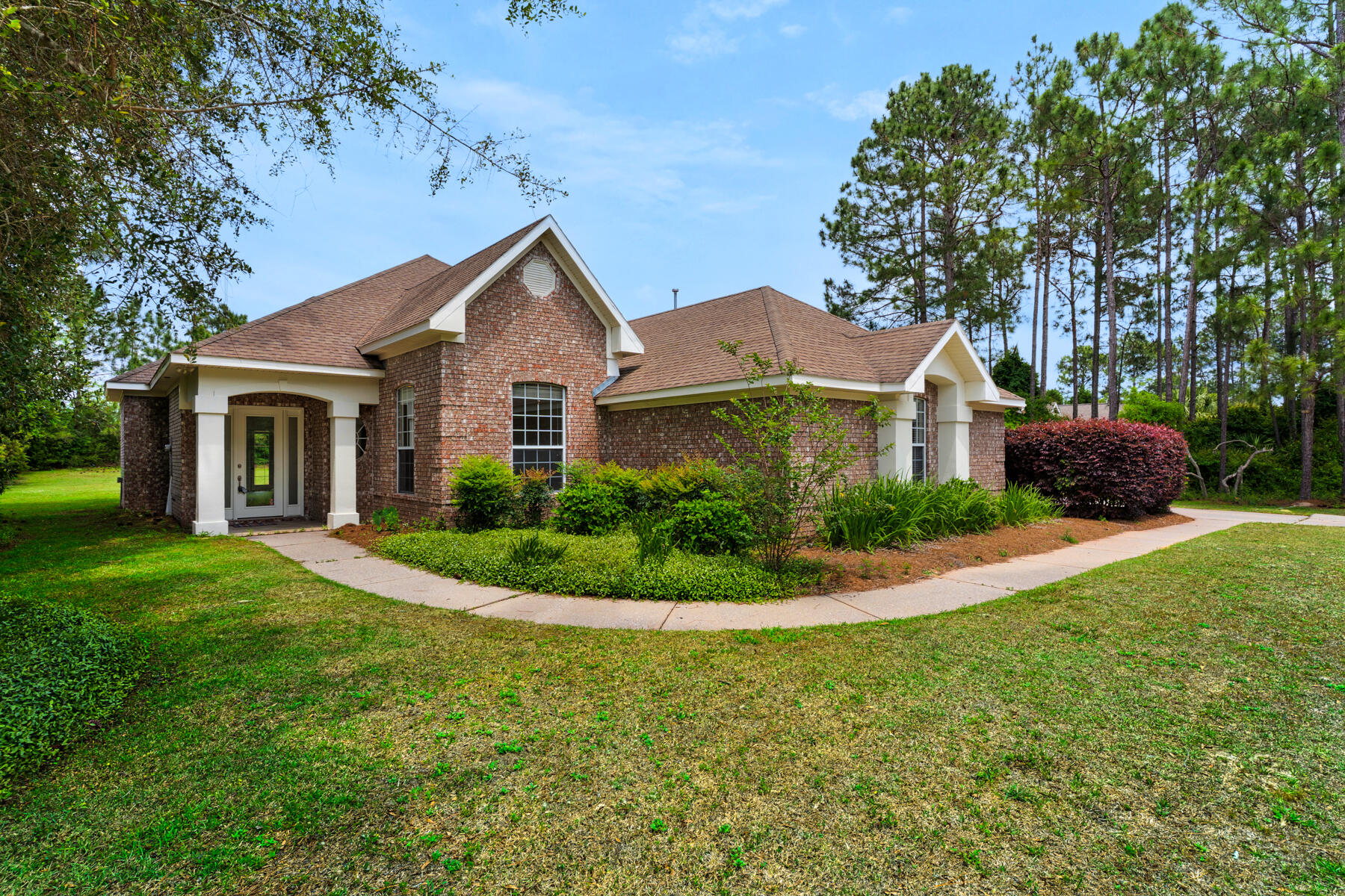 a front view of a house with a yard and potted plants