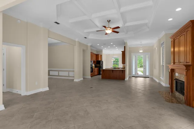 a view of a livingroom with furniture a ceiling fan window and a kitchen