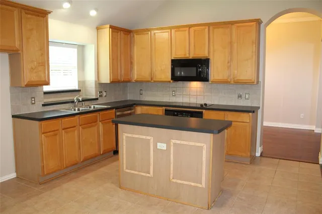 a kitchen with stainless steel appliances granite countertop a sink stove and microwave