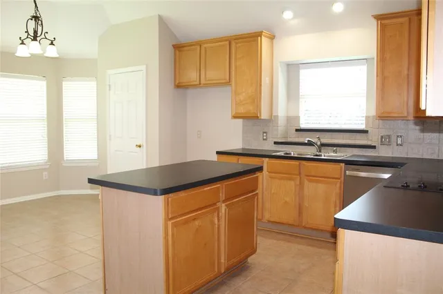 a kitchen with granite countertop a sink and a stove