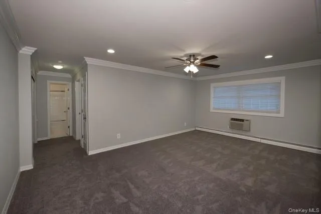 an empty room with a ceiling fan and window