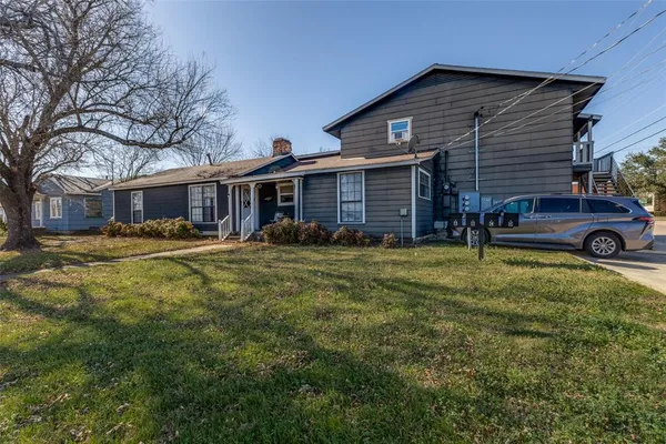 a kitchen with stainless steel appliances granite countertop a stove top oven a sink dishwasher and a refrigerator with wooden floor