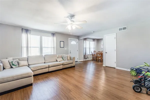 a kitchen with stainless steel appliances granite countertop a refrigerator oven a sink dishwasher and white cabinets with wooden floor