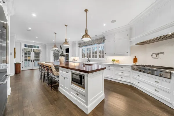 a dining room with wooden floor a chandelier a wooden table and chairs