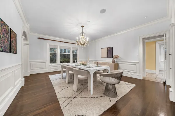 a view of a dining room with furniture a chandelier and wooden floor