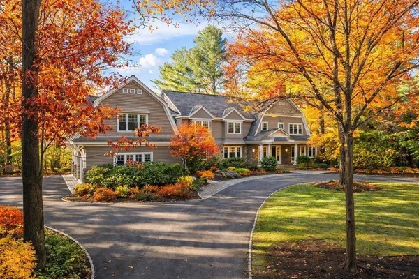 a front view of a house with a garden and trees
