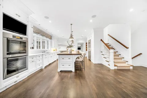 a kitchen with stainless steel appliances kitchen island granite countertop a stove and a wooden floors
