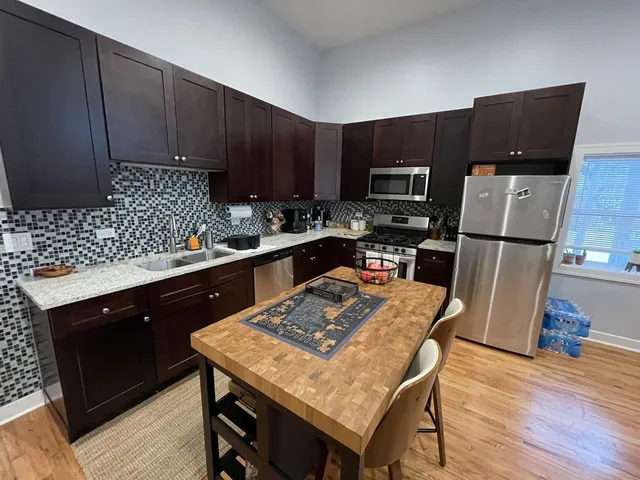 a kitchen with stainless steel appliances wooden cabinets sink and stove