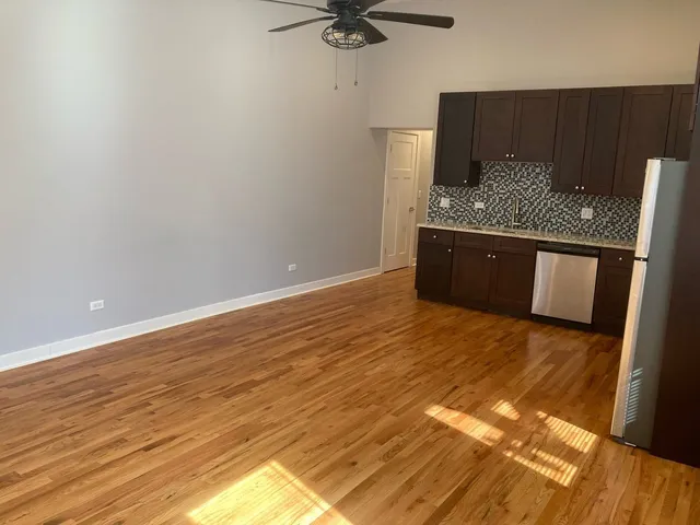 a view of kitchen with granite countertop window and refrigerator