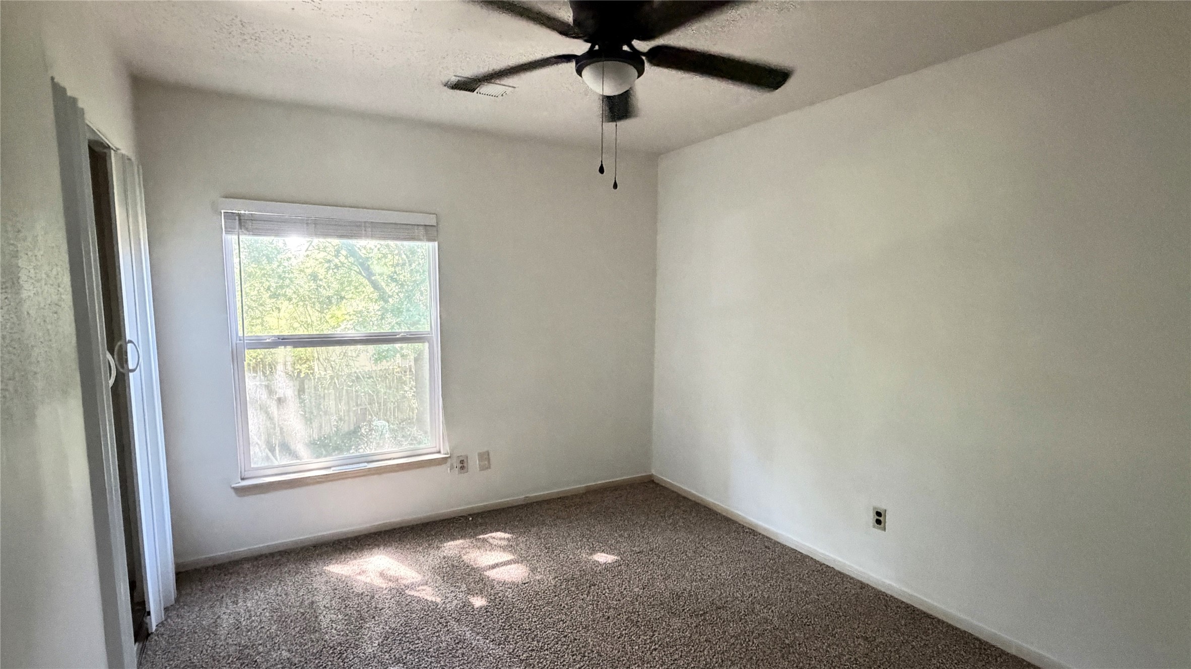 7771 Springville Drive Houston, TX 77095 - Photo 11 of 13 Bright secondary bedroom with a ceiling fan and large window.