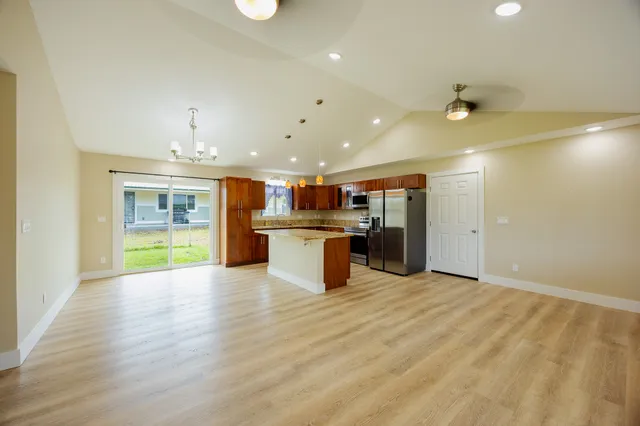 a kitchen with a sink chandelier and wooden floor