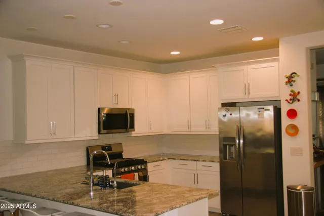 a kitchen with a refrigerator and a stove top oven