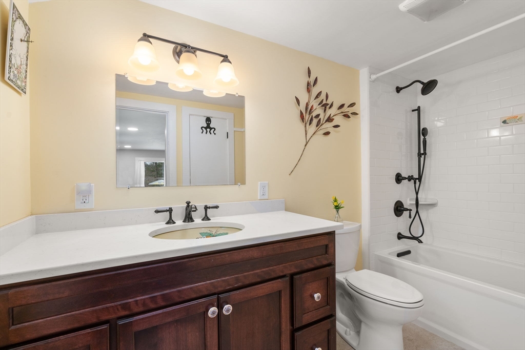 142 Plain Road Wayland, MA 01778 - Photo 8 of 14 a bathroom with a sink a toilet a mirror a vanity and shower