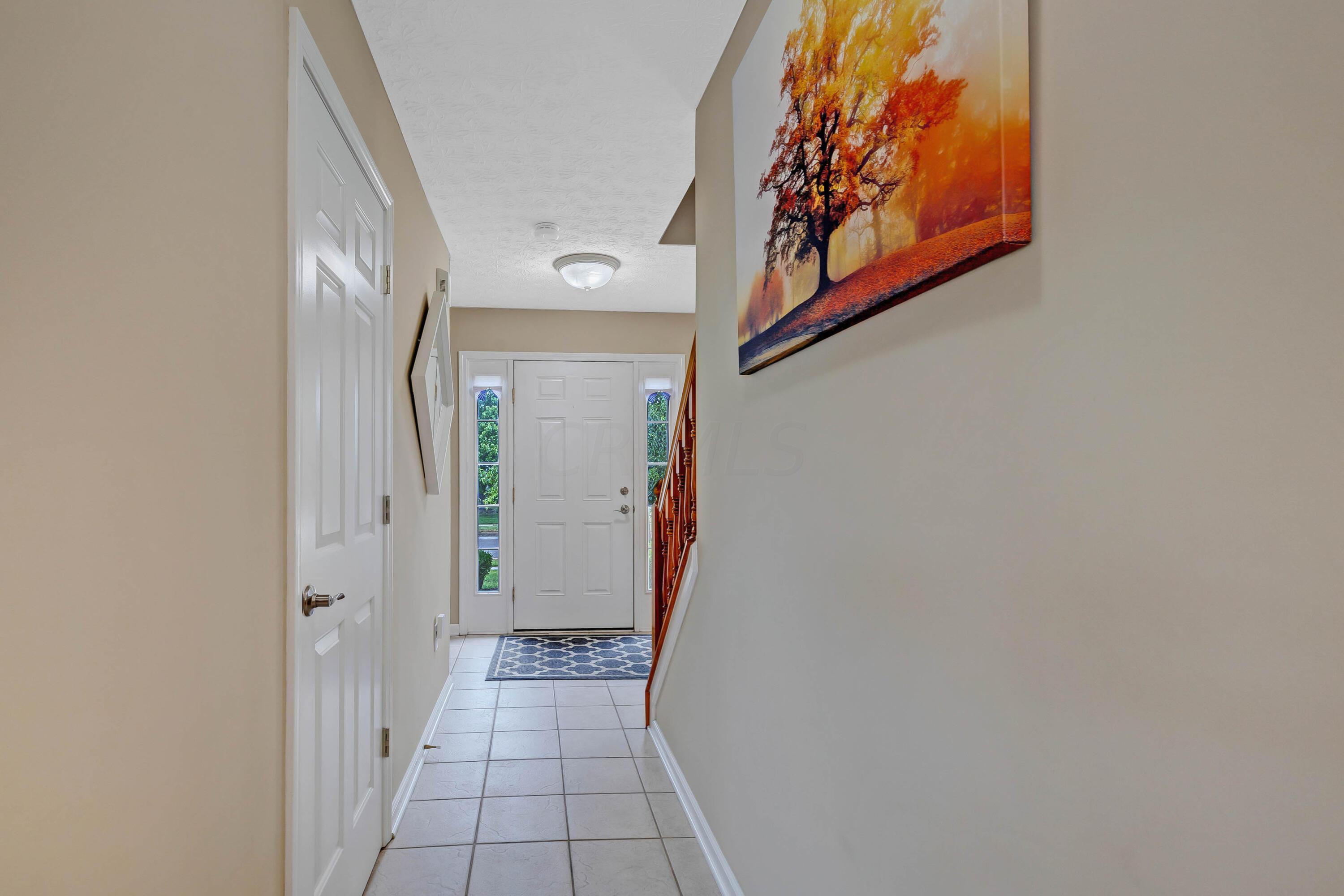 2136 Reeves Avenue Lewis Center, OH 43035 - Photo 4 of 57 • Ceramic tile flooring • Tan painted walls • Sidelights by front door • Ceiling lights • Coat closet