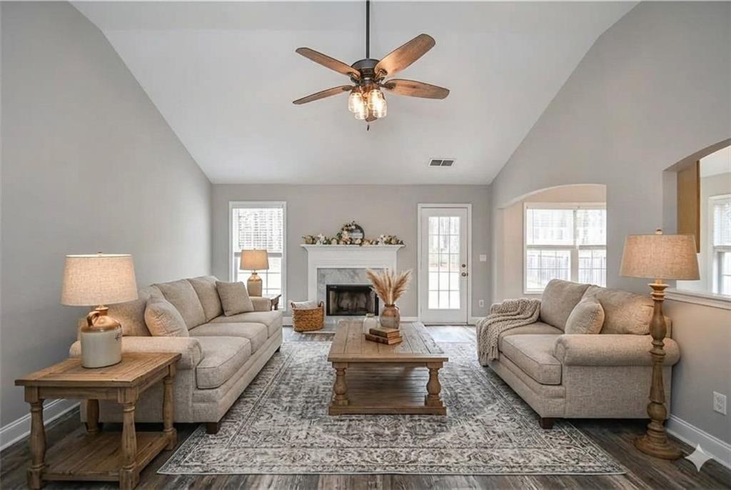 75 Ashebrooke Way Jefferson, GA 30549 - Photo 16 of 84 a living room with furniture a fireplace and a chandelier