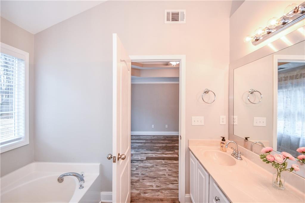 75 Ashebrooke Way Jefferson, GA 30549 - Photo 51 of 84 a bathroom with a bathtub sink vanity and mirror