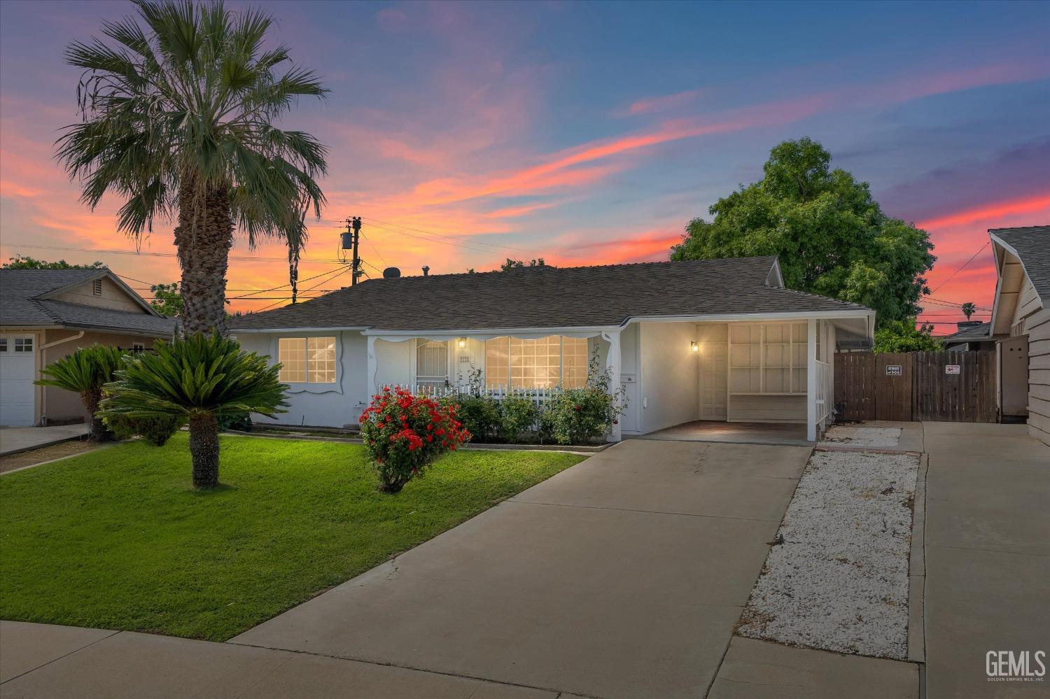 front view of house with a yard and potted plants
