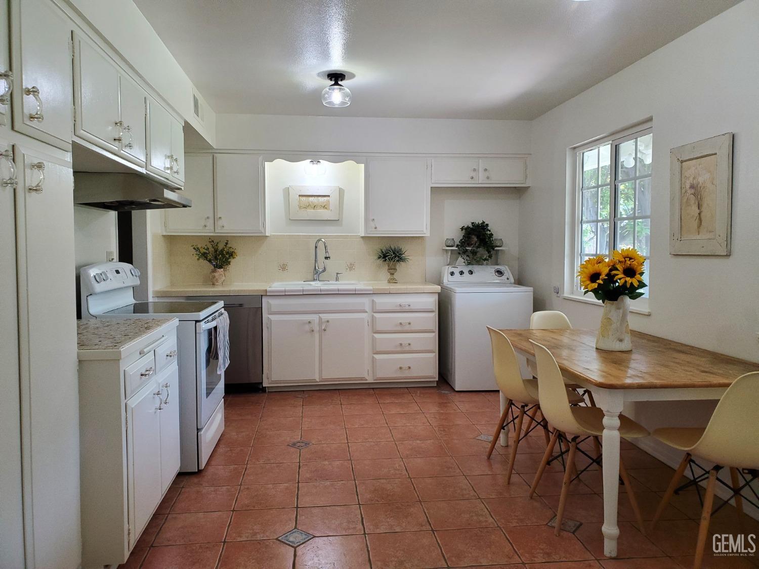 Undisclosed Address Bakersfield, CA 93309 - Photo 15 of 47 a kitchen with a sink stools a counter space and cabinets