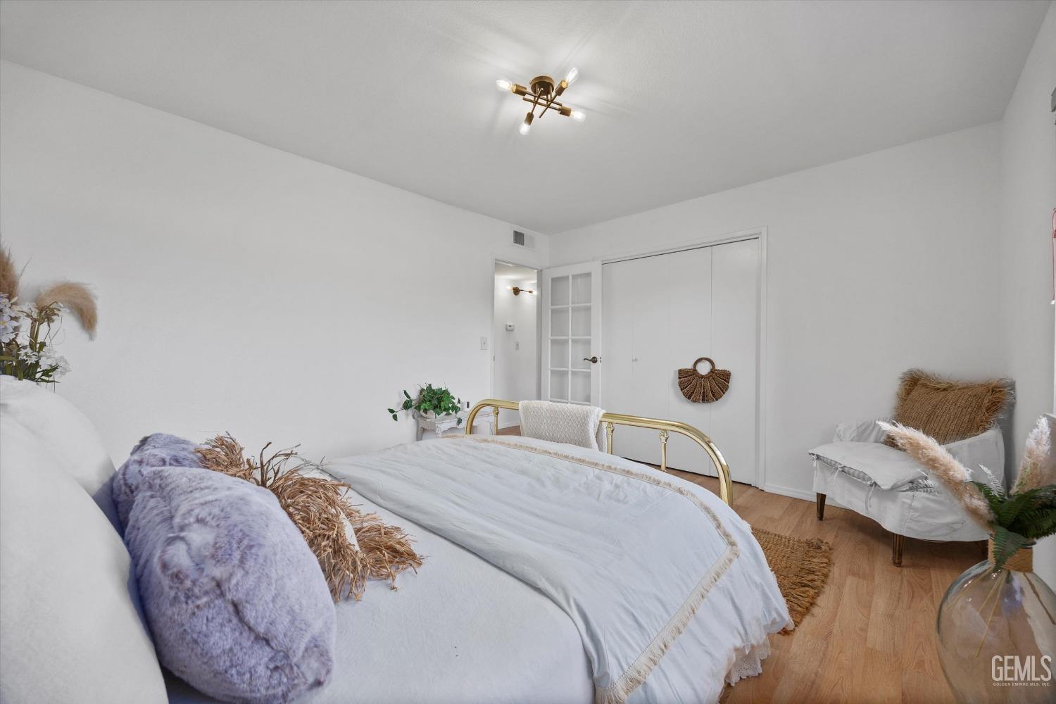 Undisclosed Address Bakersfield, CA 93309 - Photo 20 of 47 a spacious bedroom with two beds and a chandelier