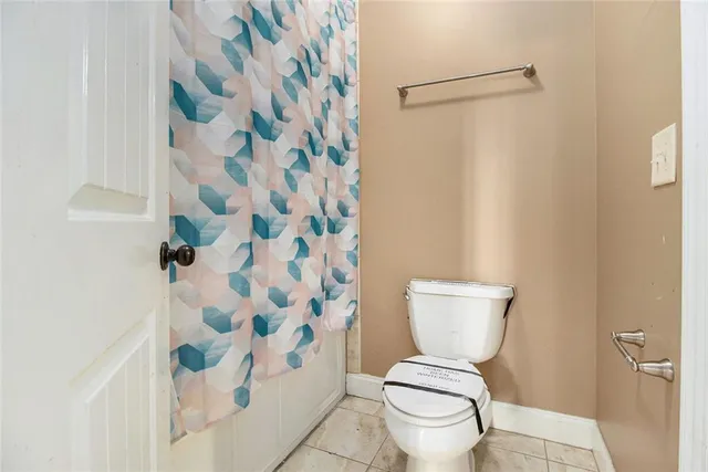 a white toilet sitting next to a shower curtain