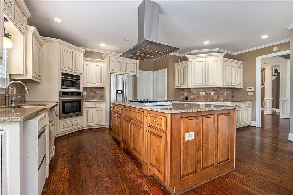70 Alcovy Reserve Way Covington, GA 30014 - Photo 10 of 30 a kitchen with stainless steel appliances granite countertop a refrigerator a stove a sink and white cabinets with wooden floor