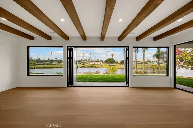 a front view of a house with garden space and palm trees