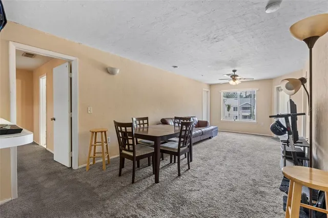 a living room with furniture a flat screen tv and a view of kitchen