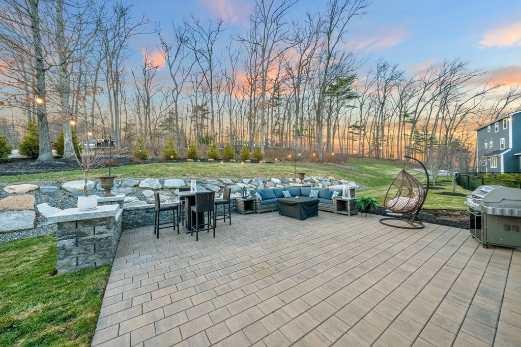 62 Seven Sister Road Haverhill, MA 01830 - Photo 40 of 42 a view of a patio with table and chairs and potted plants and large trees
