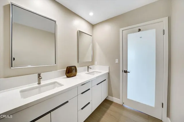 a spacious bathroom with a double vanity sink a mirror and shower