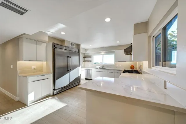 a view of kitchen with refrigerator cabinets and wooden floor