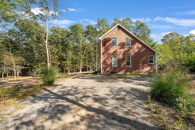 a view of a house with backyard and trees