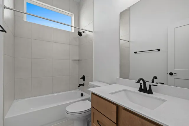 a spacious bathroom with a granite countertop sink mirror and shower