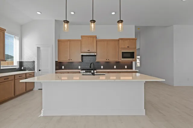 a view of kitchen with stainless steel appliances granite countertop a sink a stove and a refrigerator