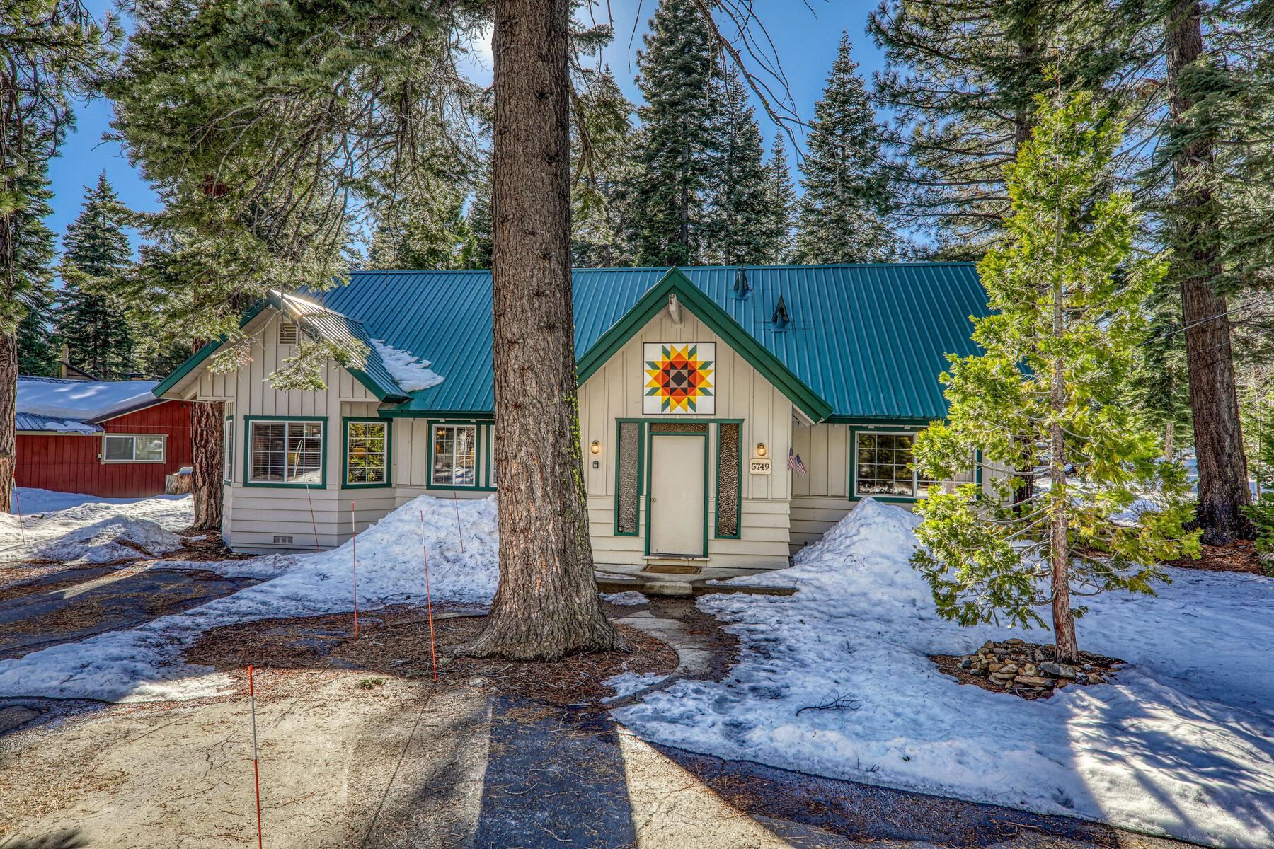 a front view of house with yard and trees in the background