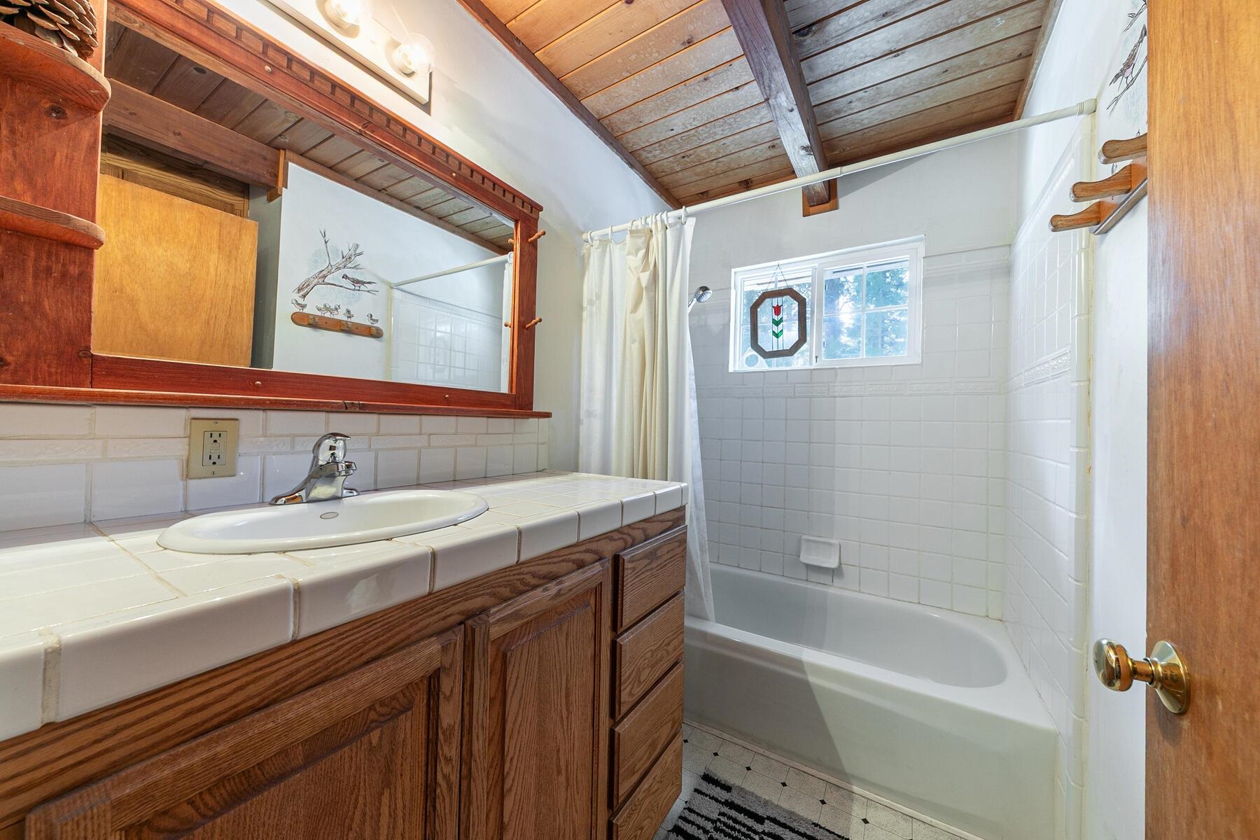 5749 Dodowah Road Carnelian Bay, CA 96140 - Photo 16 of 28 a bathroom with a sink a mirror and a bathtub