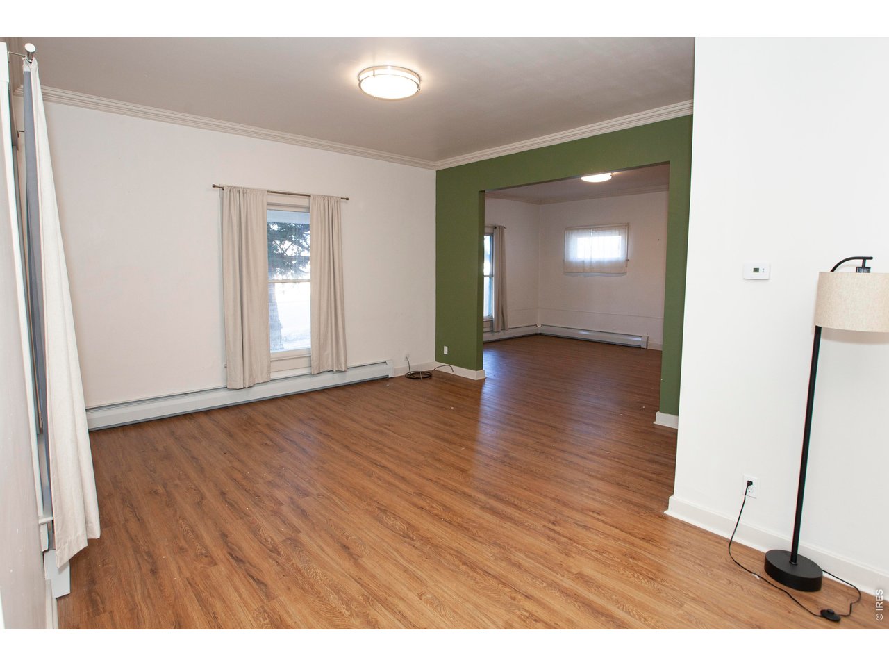 301 South 2nd Street Sterling, CO 80751 - Photo 12 of 49 a view of an empty room with wooden floor and a mirror
