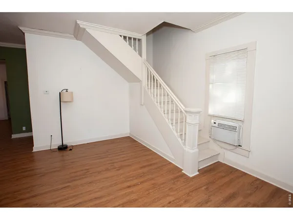 a view of an empty room with wooden floor